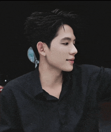 a young man in a black shirt is looking at something