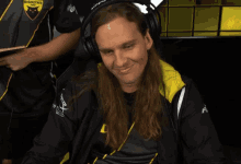 a man wearing headphones is sitting in front of a game 1 up next screen
