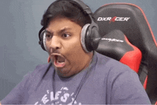 a man wearing headphones sitting in a dxr racer chair