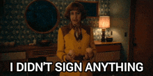 a woman in a yellow jacket holds two eggs and says " i didn 't sign anything "