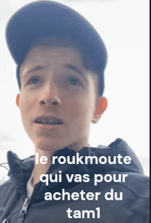 a young man wearing a black jacket and a black hat with the words le roukmouette qui vas pour acheter du tam1 below him