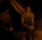a man sitting next to a woman holding a bottle of beer