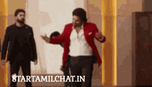 a man in a red jacket is dancing in a room with starttamilchat.in written on the bottom