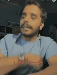 a man in a blue shirt with arabic writing on it