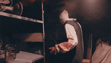 a man in a costume is standing in front of a shelf