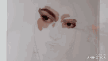 a person is painting a woman 's face with a brush on a piece of paper .