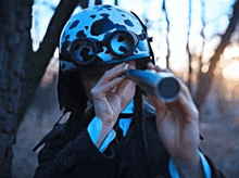 a man wearing a helmet and goggles looks through a telescope
