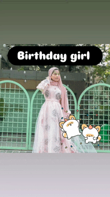 a girl in a pink dress is standing in front of a green fence with the words birthday girl written above her