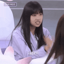 a girl in a purple shirt is talking to another girl in a pink shirt