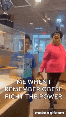 a woman in a pink shirt is walking with a boy in a restaurant .