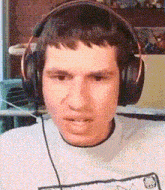 a man is wearing headphones and making a face