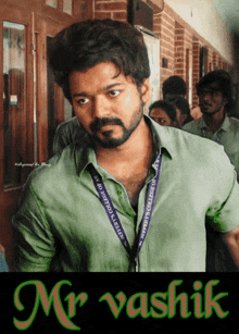 a man in a green shirt with a lanyard that says mr. vashik on it