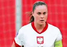 a female soccer player wearing a white jersey with a red eagle on the front
