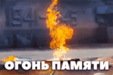 a fire is burning in front of a wall that says ' огонь памяти '