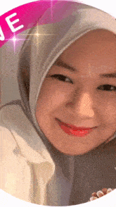 a woman wearing a hijab is smiling in a pink circle with the letter e