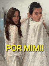 two women standing next to each other with the words por mim written in yellow