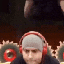 a man wearing headphones and a hat is looking at something .