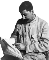 a black and white photo of a man with a mustache reading a book