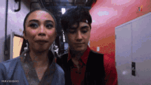 a man and a woman are standing next to each other in a hallway with mayward written on the bottom of the image