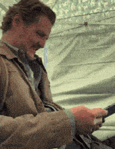a man with a beard is using a cell phone