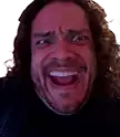 a man with long hair and a beard is smiling with his mouth open .