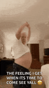 a man is dancing in a living room with his arms outstretched .
