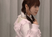 a woman in a pink dress with ruffles on the sleeves