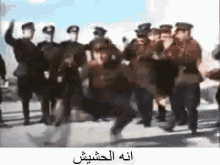 a group of soldiers are marching in a line with arabic writing on the bottom .