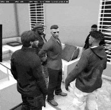 a black and white photo of a group of men standing in a living room with the cpu and gpu displayed