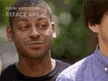 a man in a black shirt is making a funny face while standing next to another man in a blue shirt .