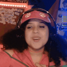 a woman wearing headphones and a red hat with the letter e on it