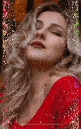 a woman with her eyes closed is wearing a red dress