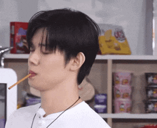 a young man is eating a stick in his mouth