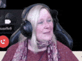 a woman wearing headphones is sitting in a chair in front of a screen that says pause9x9