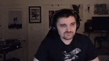 a man wearing headphones is sitting in front of a computer in a room .