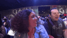 a man with curly hair is sitting in a crowd with the words you 're above him