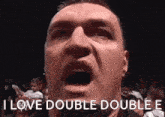 a man is making a funny face with his mouth open and the words `` i love double double e '' .