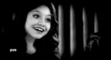 a man is smiling in a black and white photo while sitting next to a woman .