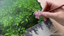 a person is painting flowers with a brush on a canvas that says wow art made in animatica