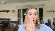 a woman blowing a kiss in front of a sign that says " welcome "