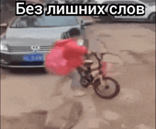 a person riding a bike in front of a car with russian writing