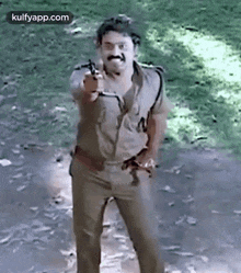 a man in a police uniform is holding a gun and pointing at the camera .