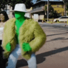 a man dressed as a hulk is walking down the street