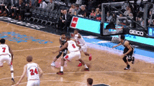 a basketball game is being played on a court with a geico ad in the background