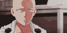 a bald man with a white shirt and black buttons on his sleeves is looking at the camera .
