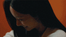 a close up of a woman 's face with long hair and a white sweater .