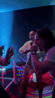 a blurry picture of a man singing into a microphone in a dark room