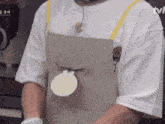 a person wearing an apron and a white shirt with tvn written on the bottom