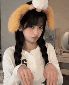 a girl wearing a headband with bunny ears and a shirt with the letter g on it