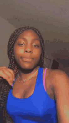 a woman is wearing a blue tank top and a pink bra